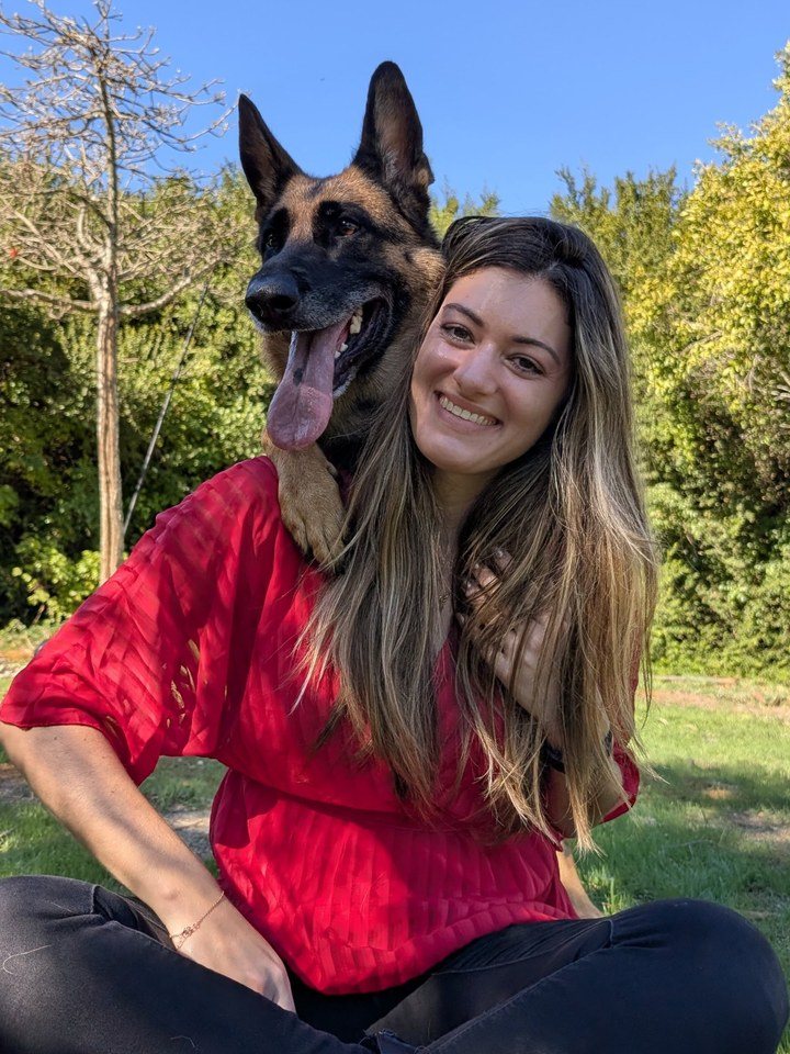Mineschke sitting on the grass with her German Shepherd Aria